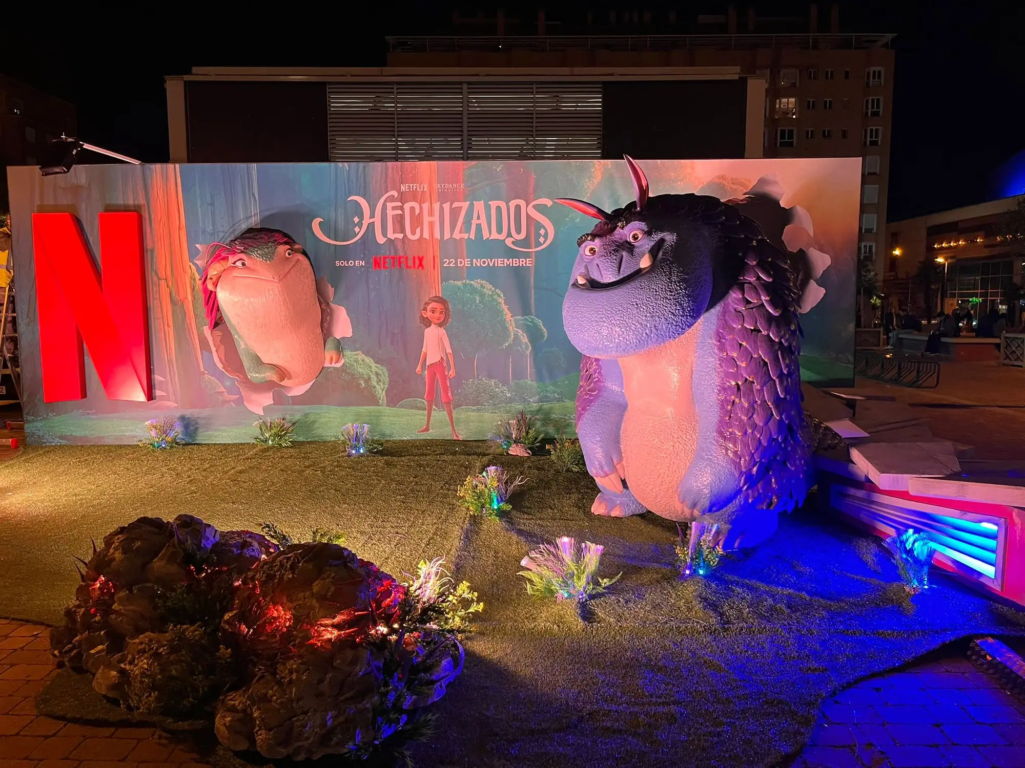 Figura publicitaria gigante del estreno de Hechizados para Netflix, con el título y la N iluminada de noche